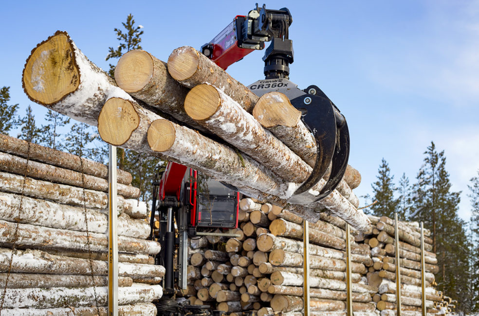 Virkesbil lastar timmer inom skogsindustrin